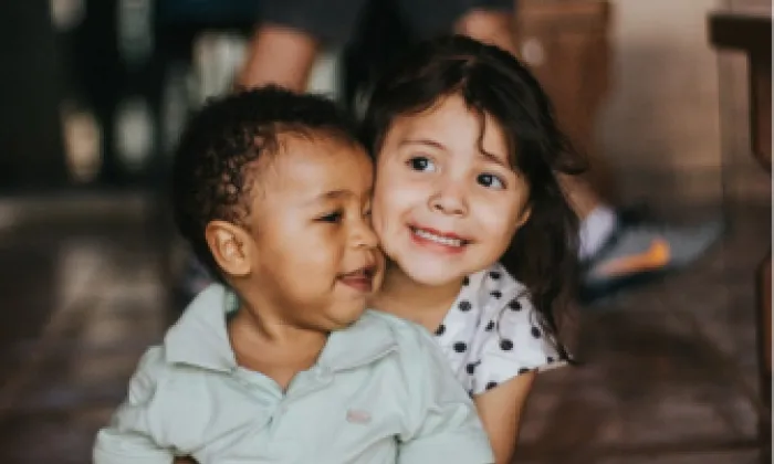 Dos niños abrazados y sonriendo